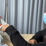 Photo of a researcher bumping fists with Nao, the robot helping assess mental wellbeing in children