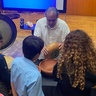 Christopher Garcia shows Mexican indigenous instruments to attendees of the workshop