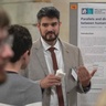 Photo of Mate Aller presenting his poster and the Annual Symposium 2022