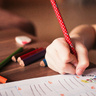 Child drawing with coloured pencils