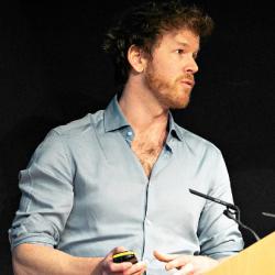 Photo of Duncan Astle talking at podium
