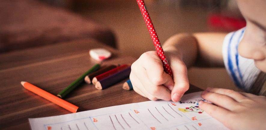 Child drawing with coloured pencils