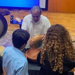 Christopher Garcia shows Mexican indigenous instruments to attendees of the workshop