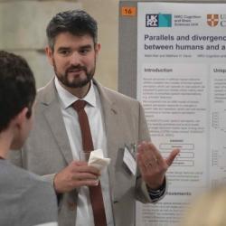 Photo of Mate Aller presenting his poster and the Annual Symposium 2022