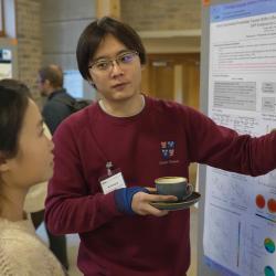 Photo of Delegates engaging with Yinhong Liu's poster