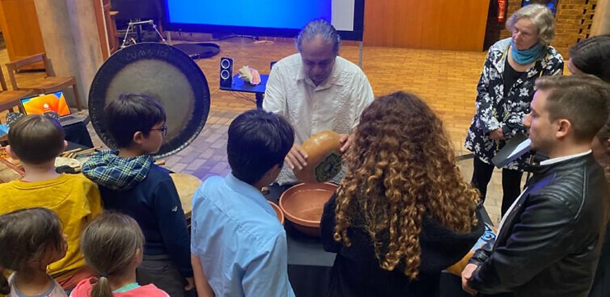 Christopher Garcia shows Mexican indigenous instruments to attendees of the workshop