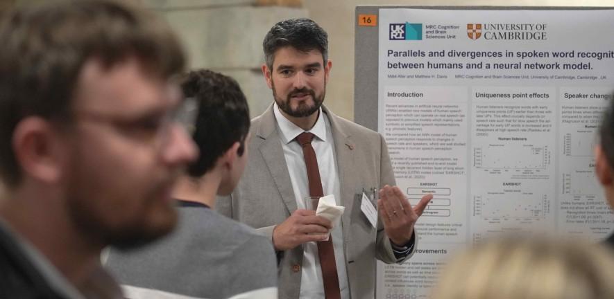 Photo of Mate Aller presenting his poster and the Annual Symposium 2022